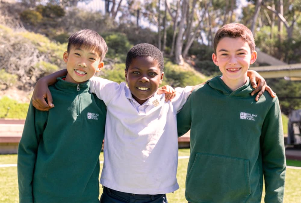 Three Del Mar Pines students smiling together outdoors