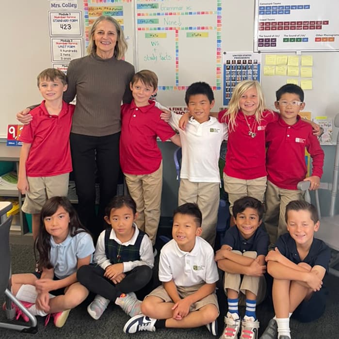 A teacher with a small group of students posing together in the classroom