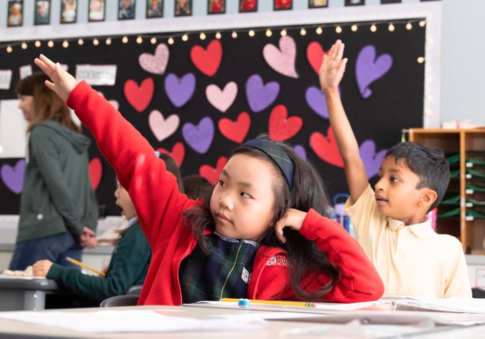 Students raising their hands during a language arts lesson