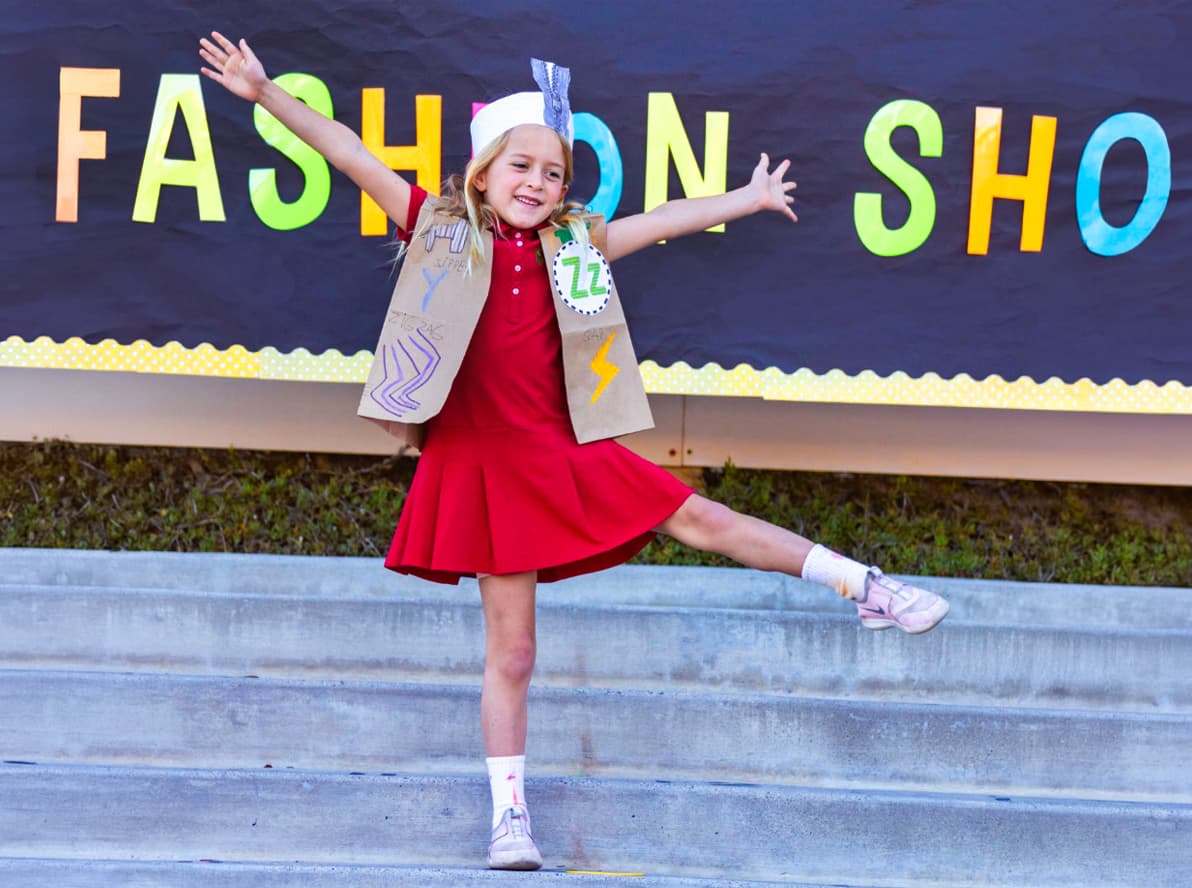 A kindergartner posing in her costume at the class fashion show