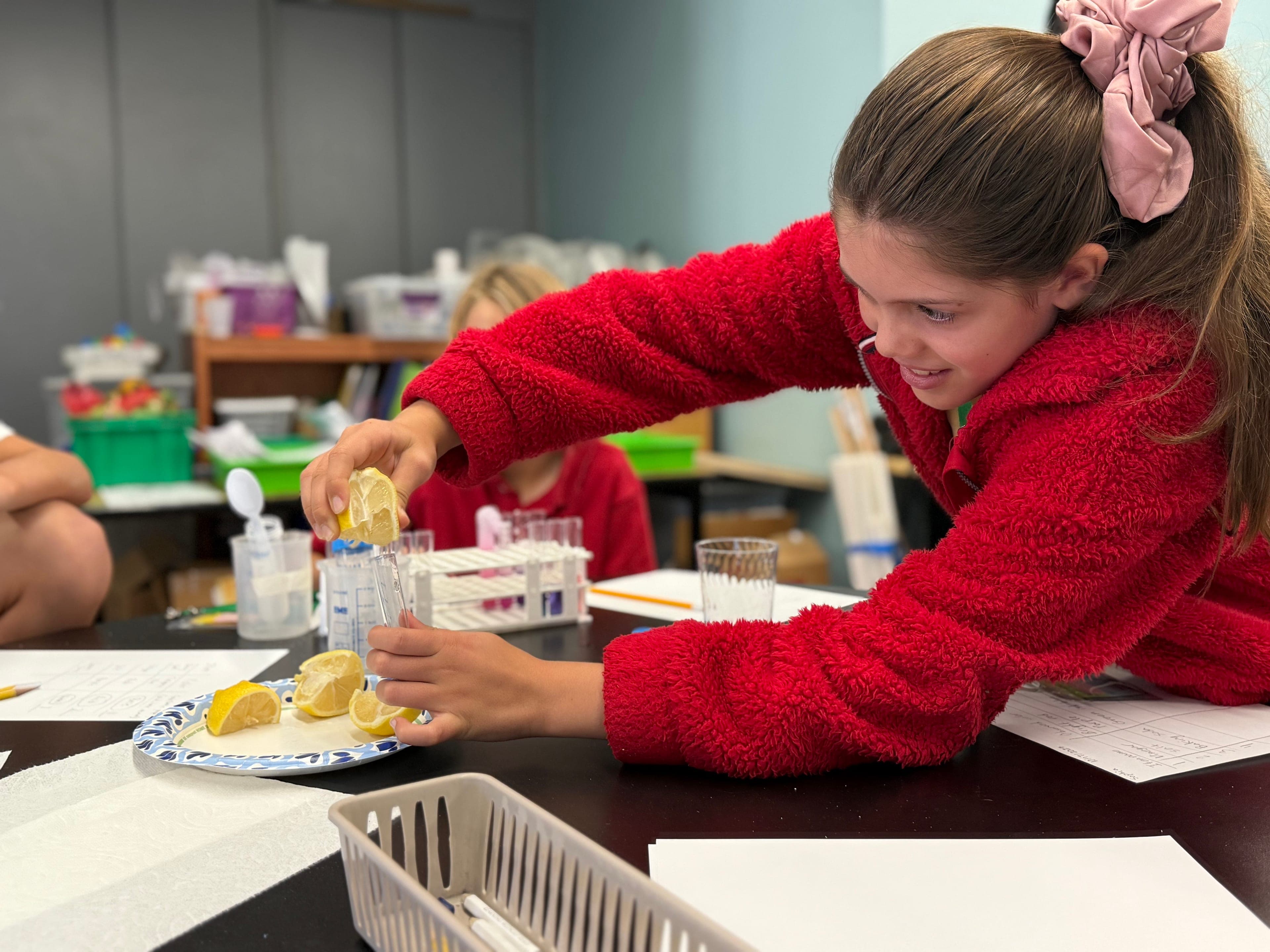 A student squeezing lemon juice into a test tube during a science experiment